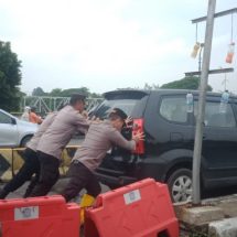 Personel Polsek Cengkareng Berjibaku di Tengah Banjir, Mendorong Mobil Mogok